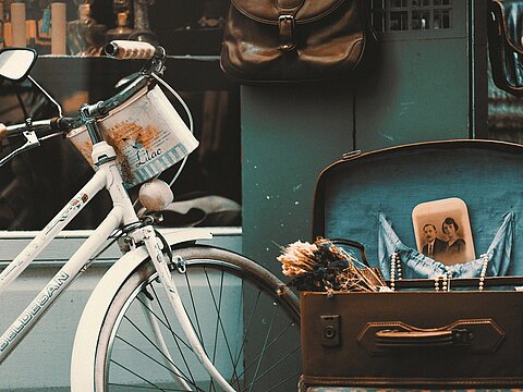 Symbolbild für individuelle E-Commerce-Lösungen – nostalgisches Fahrrad und Koffer vor Ladenszene